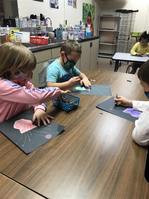 Photo shows four students creating artwork inspired by African American artist Alma Woodsey Thomas.